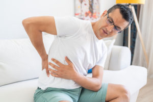 Young man with back pain. Man Having Spinal Or Kidney Pain, Backache