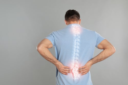 a man touching his lower back at pain point