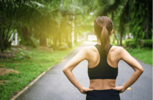 Back view of young fitness woman running on the road in the morning.