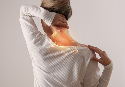 Woman suffering from back and neck pain.