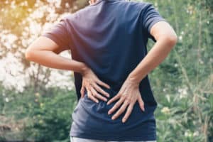 hands of woman touching her back pain