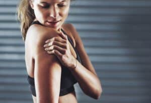 Fit woman experiences pain in her upper arm due to a herniated disc. Fit woman experiences pain in her upper arm due to a herniated disc.